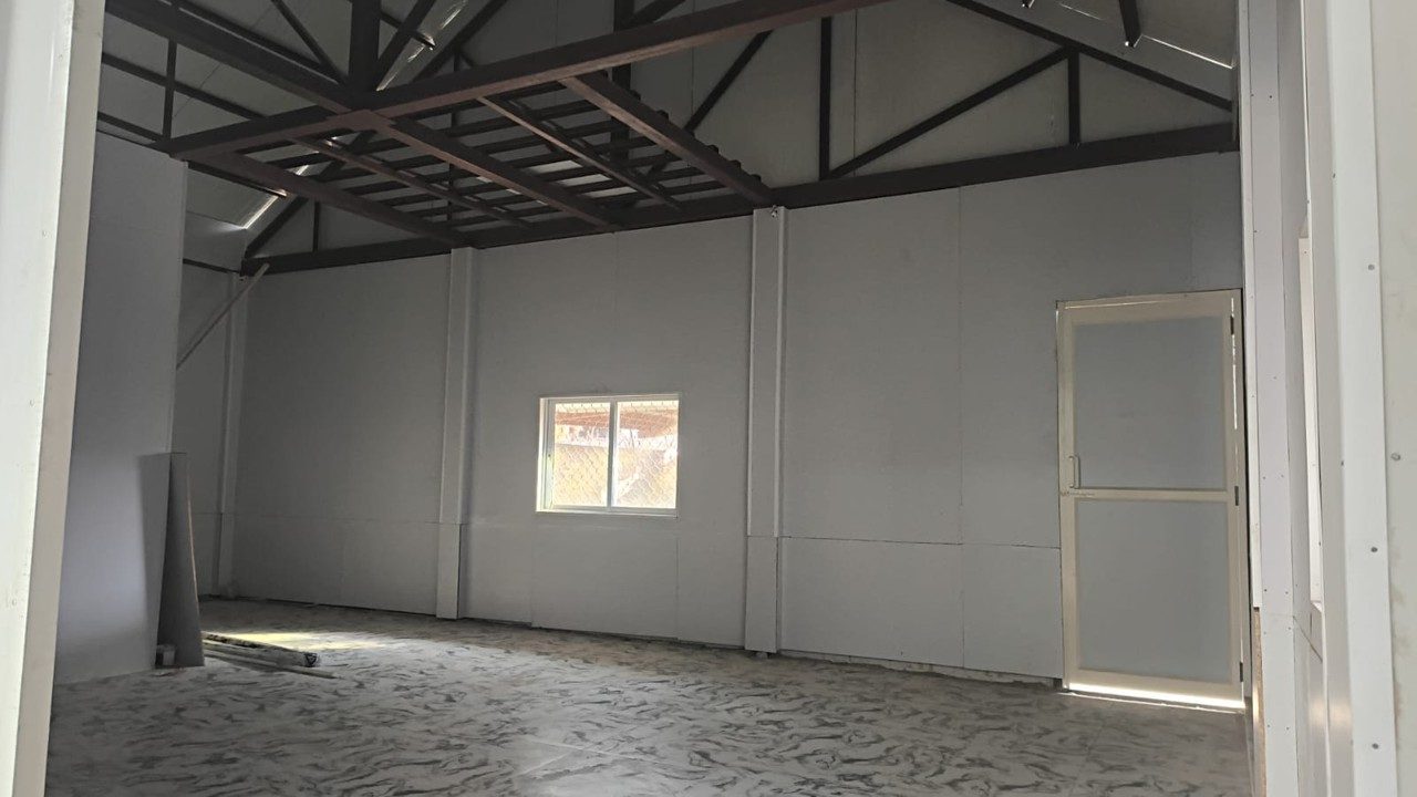 Kitchen block interior — steel truss roof system with insulated sandwich-panel walls.